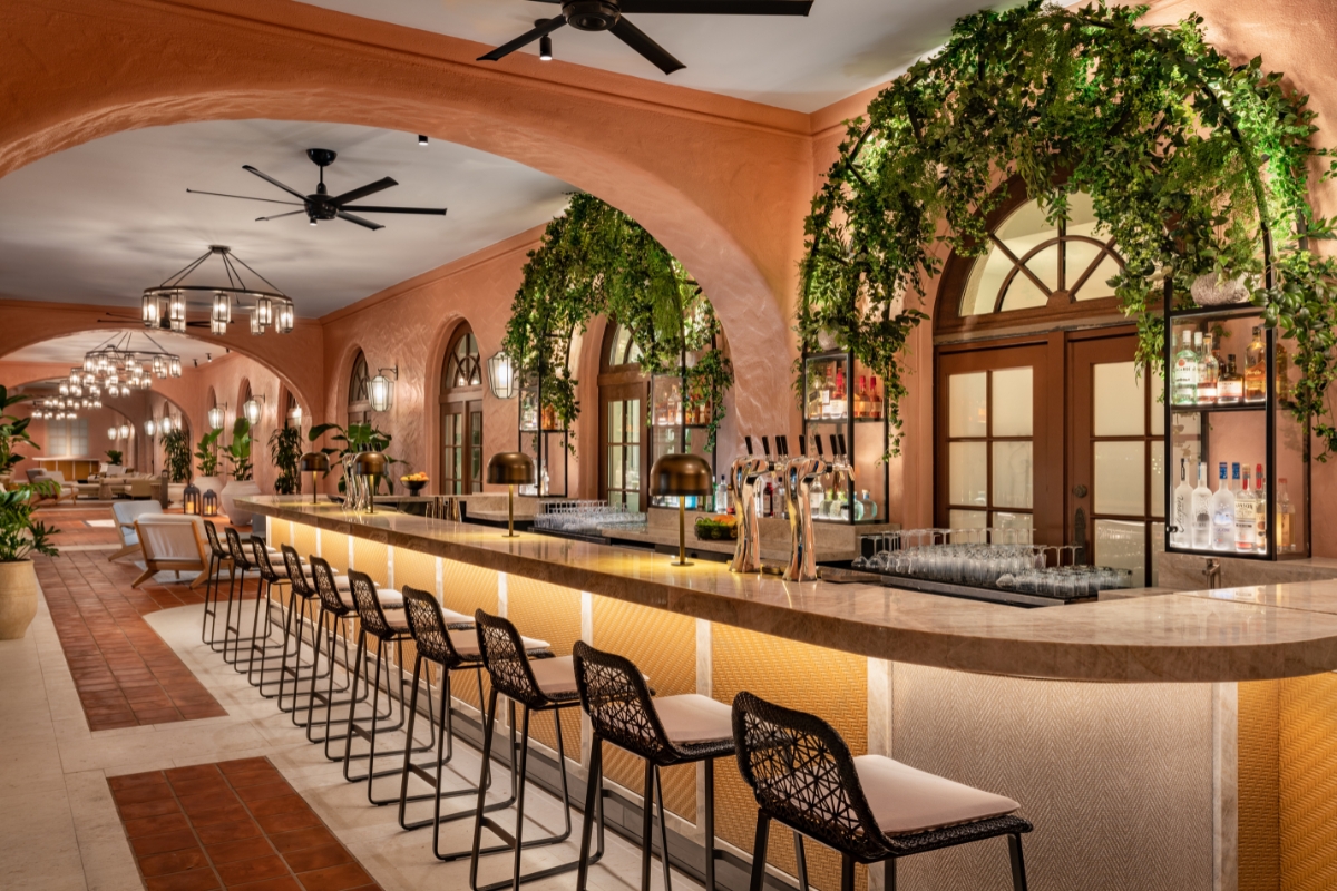 a long bar with chairs and a ceiling fan