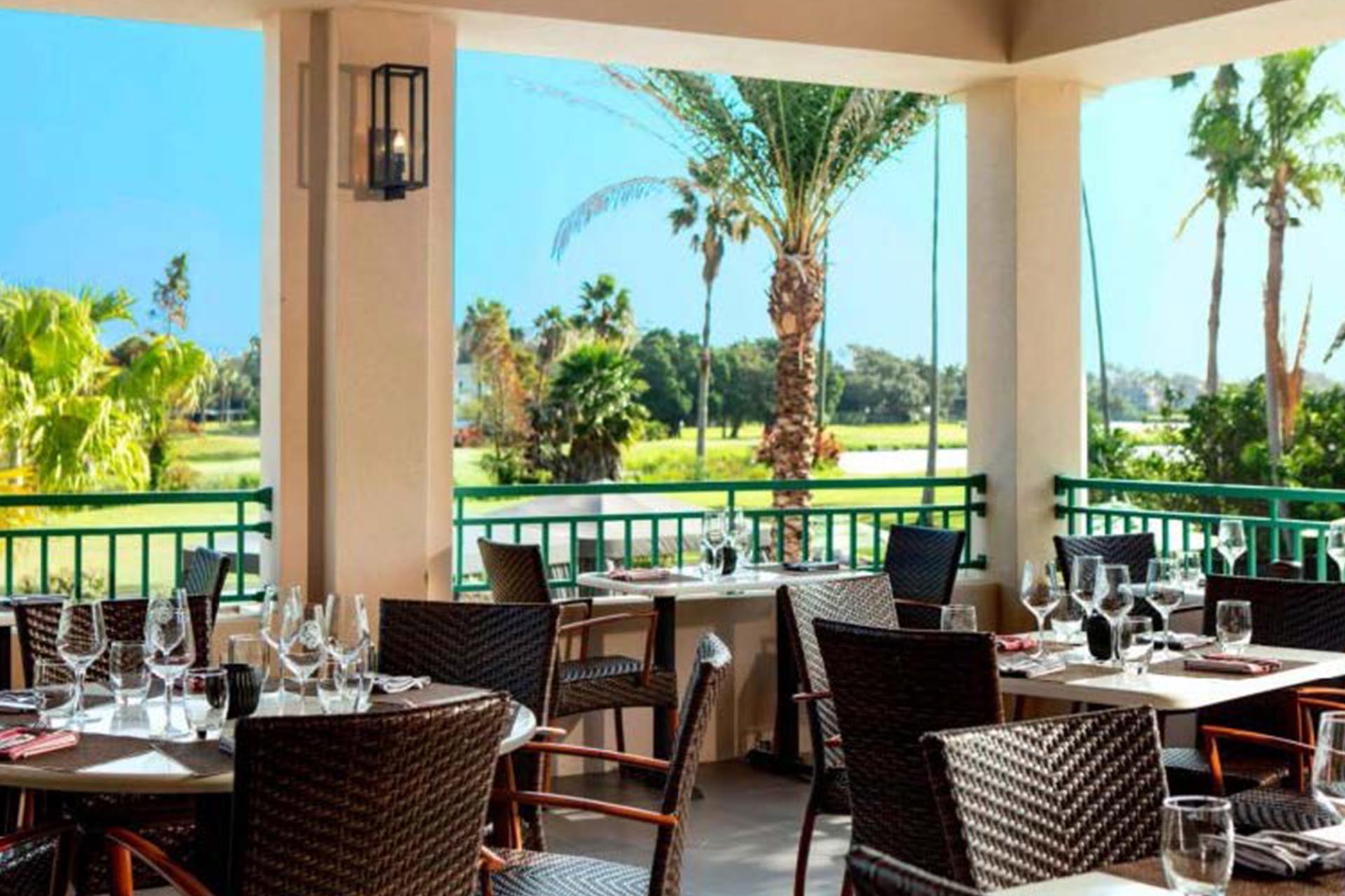 a table and chairs outside with a golf course in the background