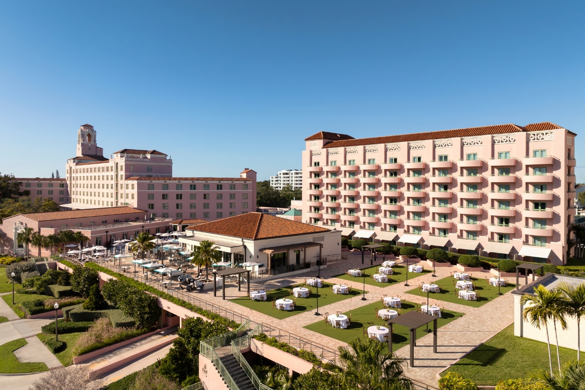 a group of buildings with tables and chairs in front of them