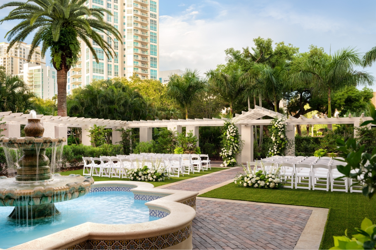 a wedding venue with white chairs and a fountain