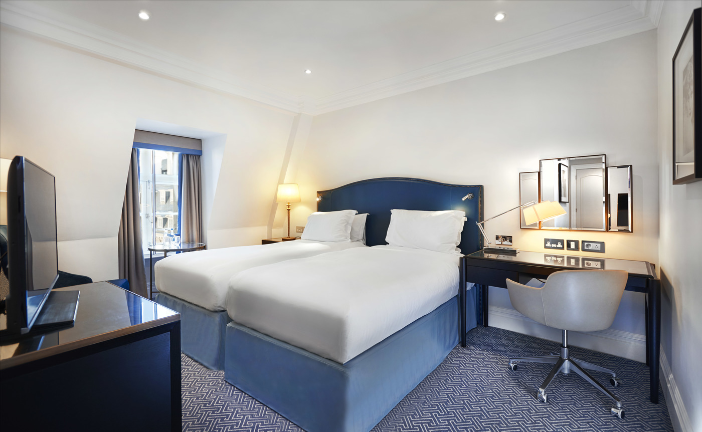 a room with two beds and a desk
