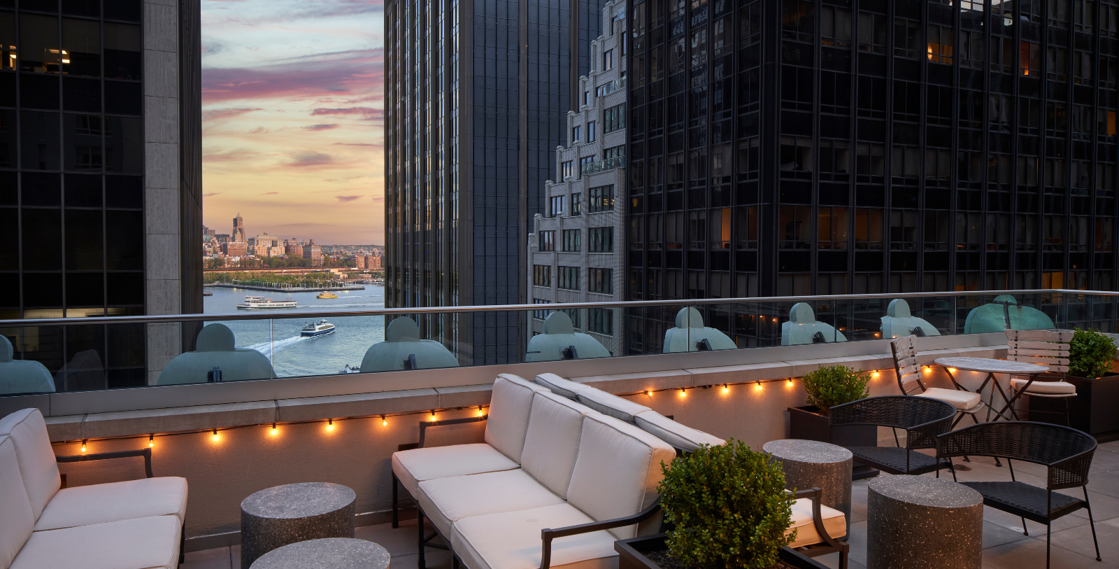 a rooftop patio with a view of a city and water