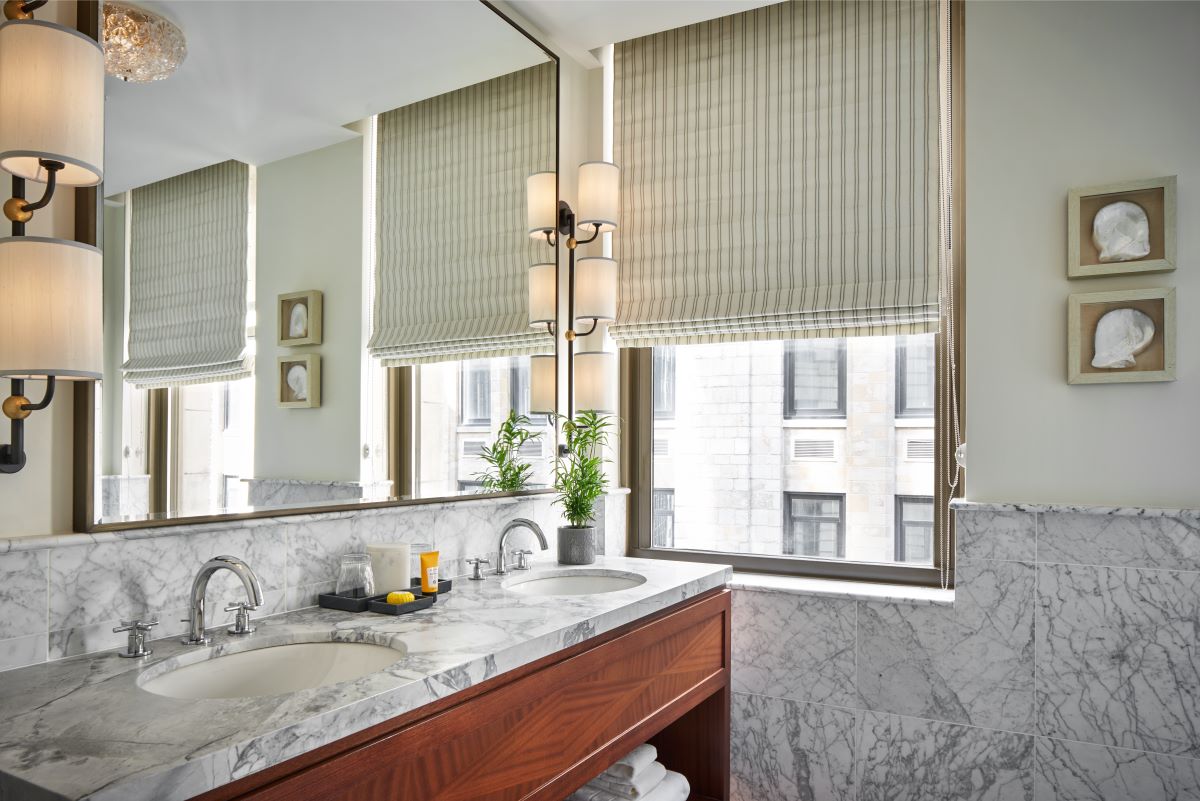 a bathroom with marble countertop and a large mirror