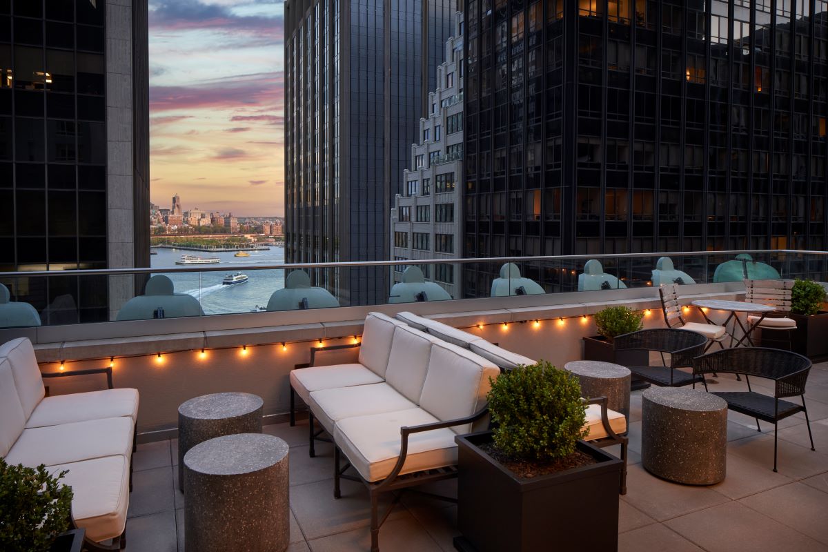a rooftop patio with a view of a city and water