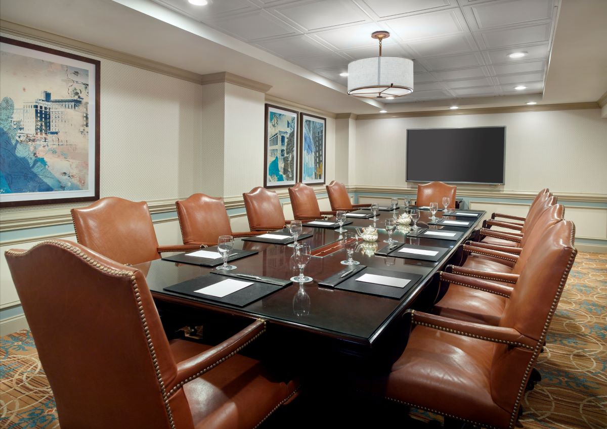 a conference room with leather chairs and a table with wine glasses