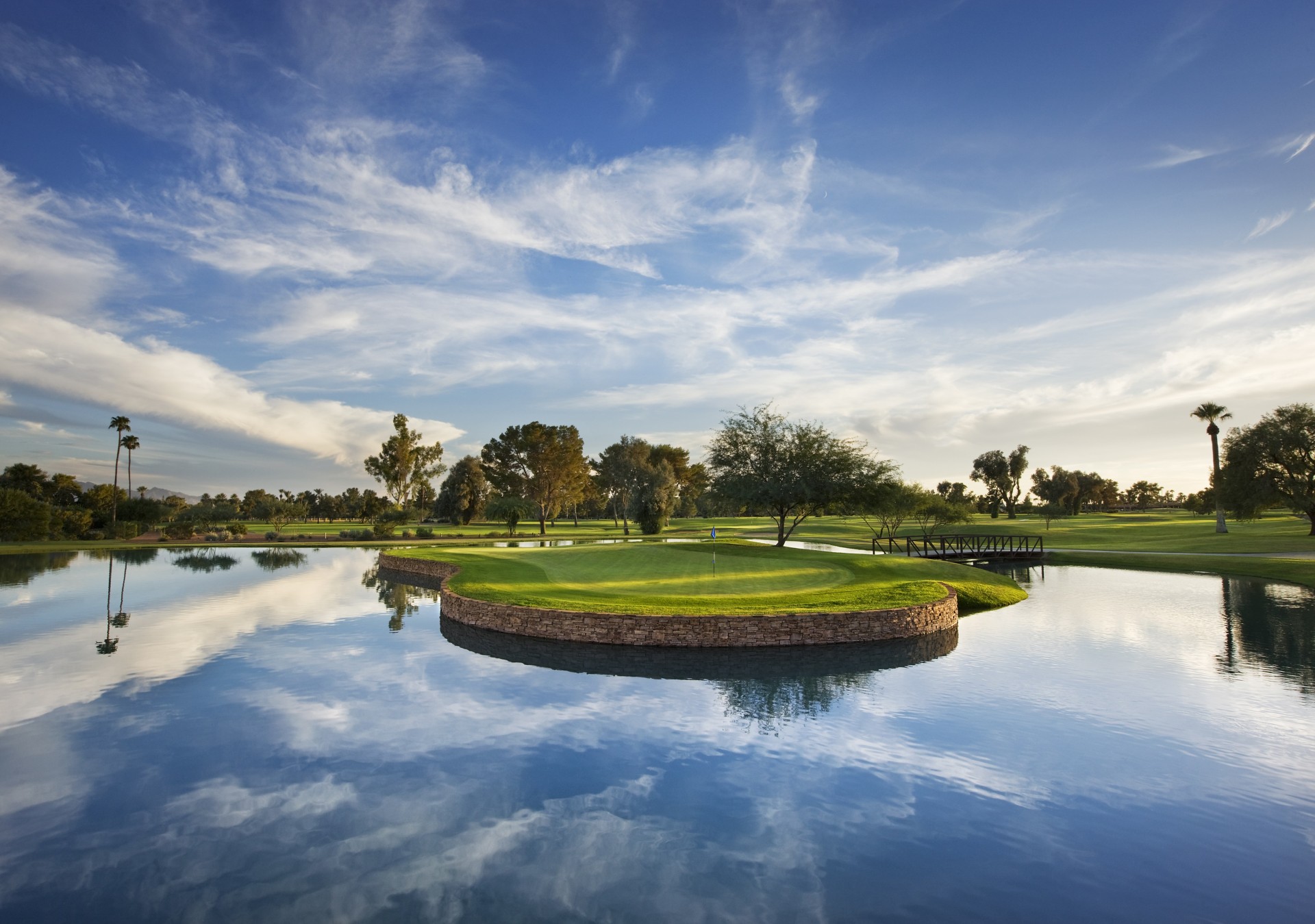 a golf course with a body of water and a small island