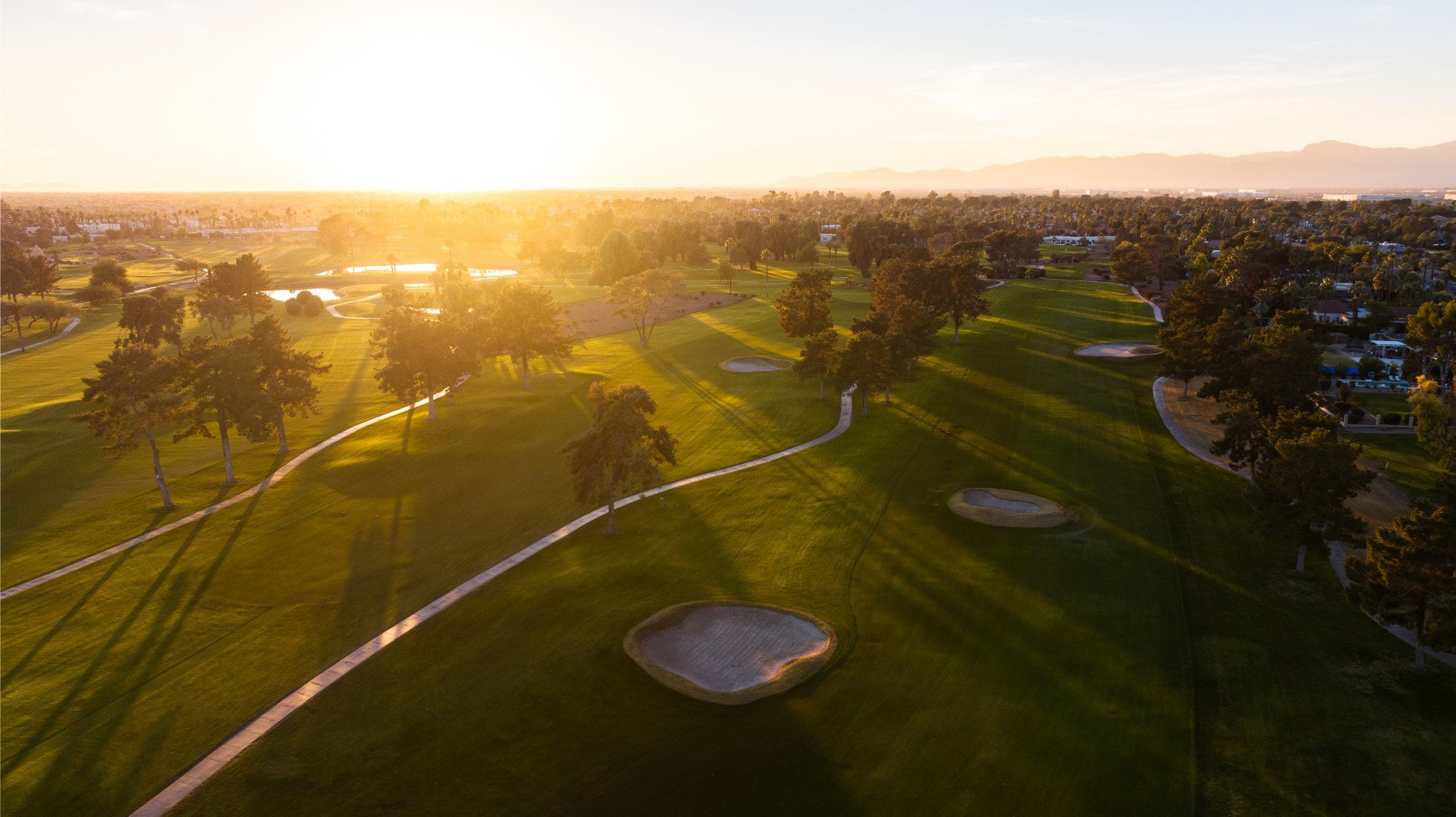 a golf course with trees and a path