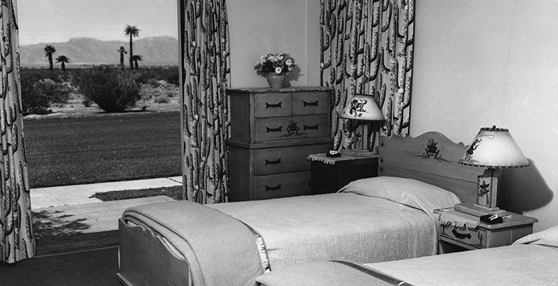 a bedroom with a dresser and bed