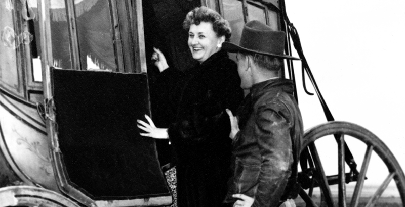 a man and woman standing next to a bus