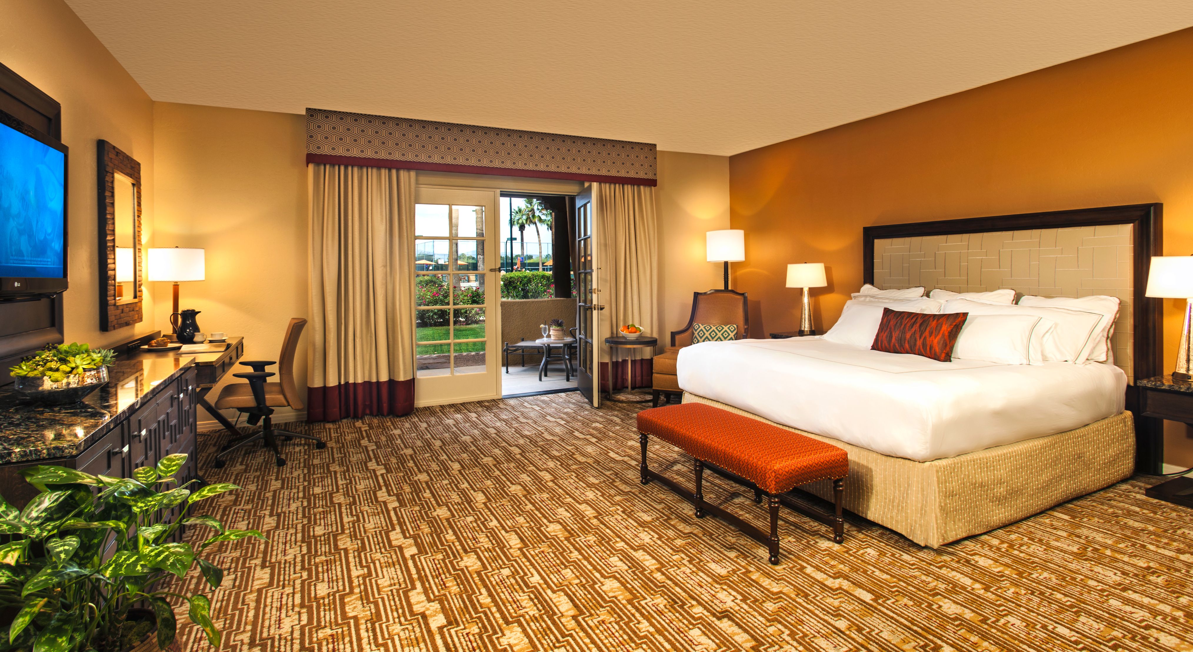a room with a bed and chairs
