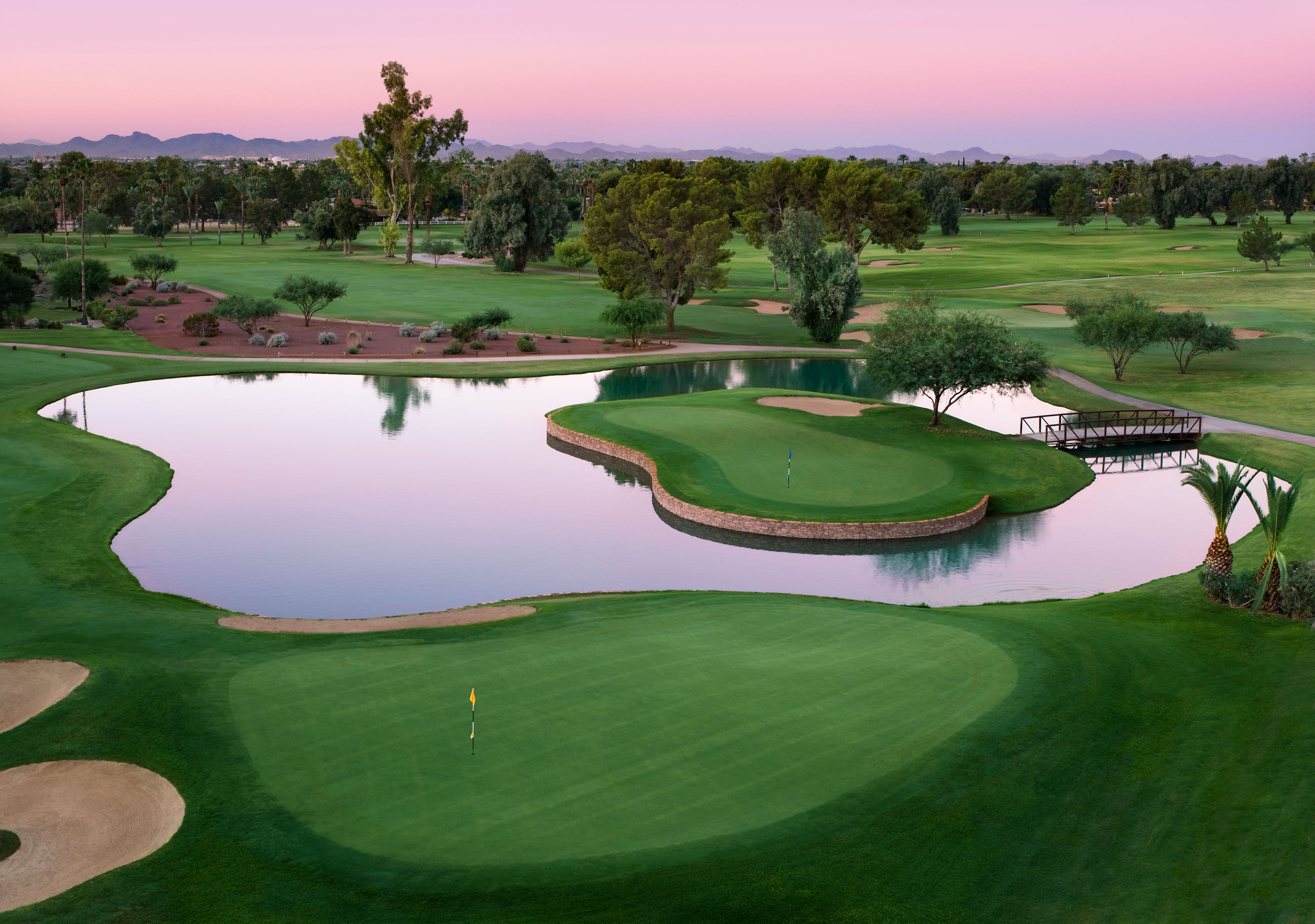 a golf course with a lake and trees