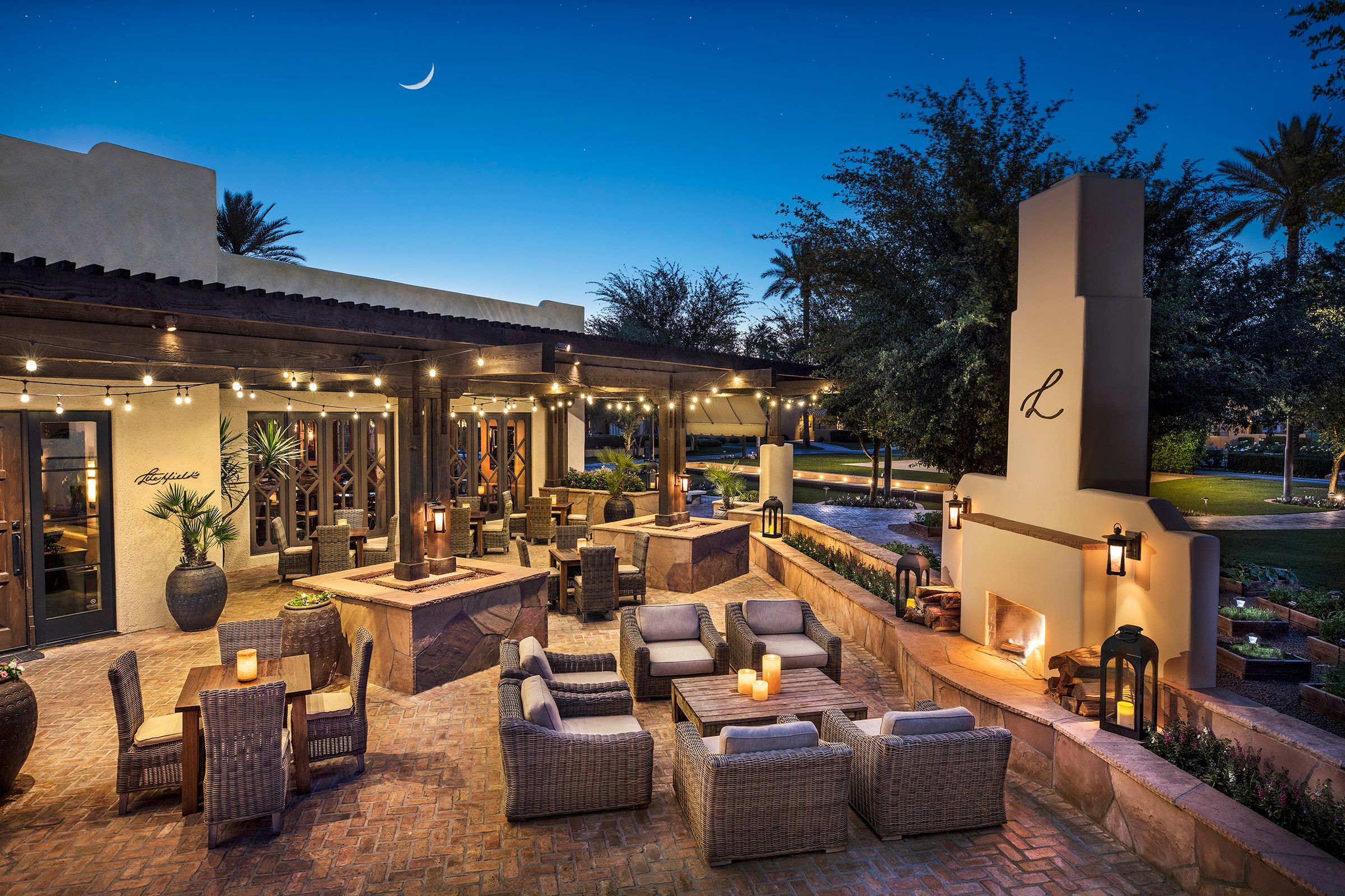 a patio with chairs and a fireplace