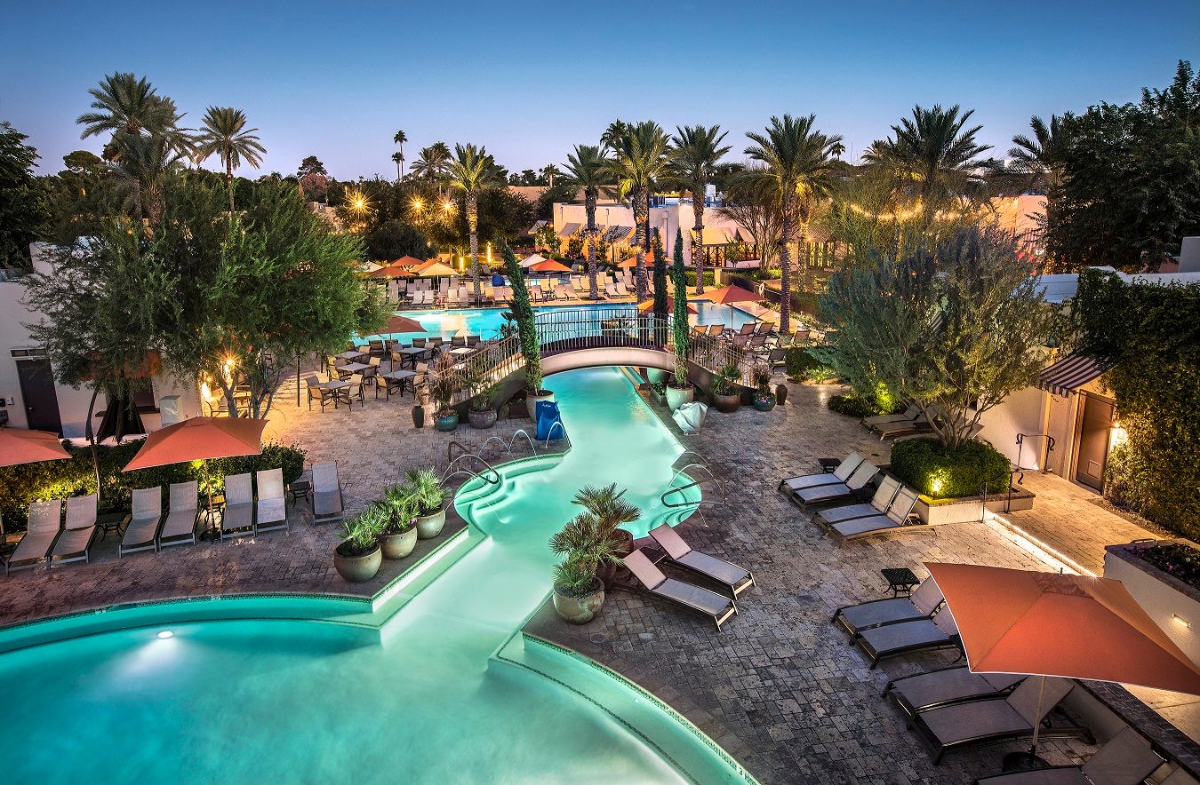 a pool with lounge chairs and trees