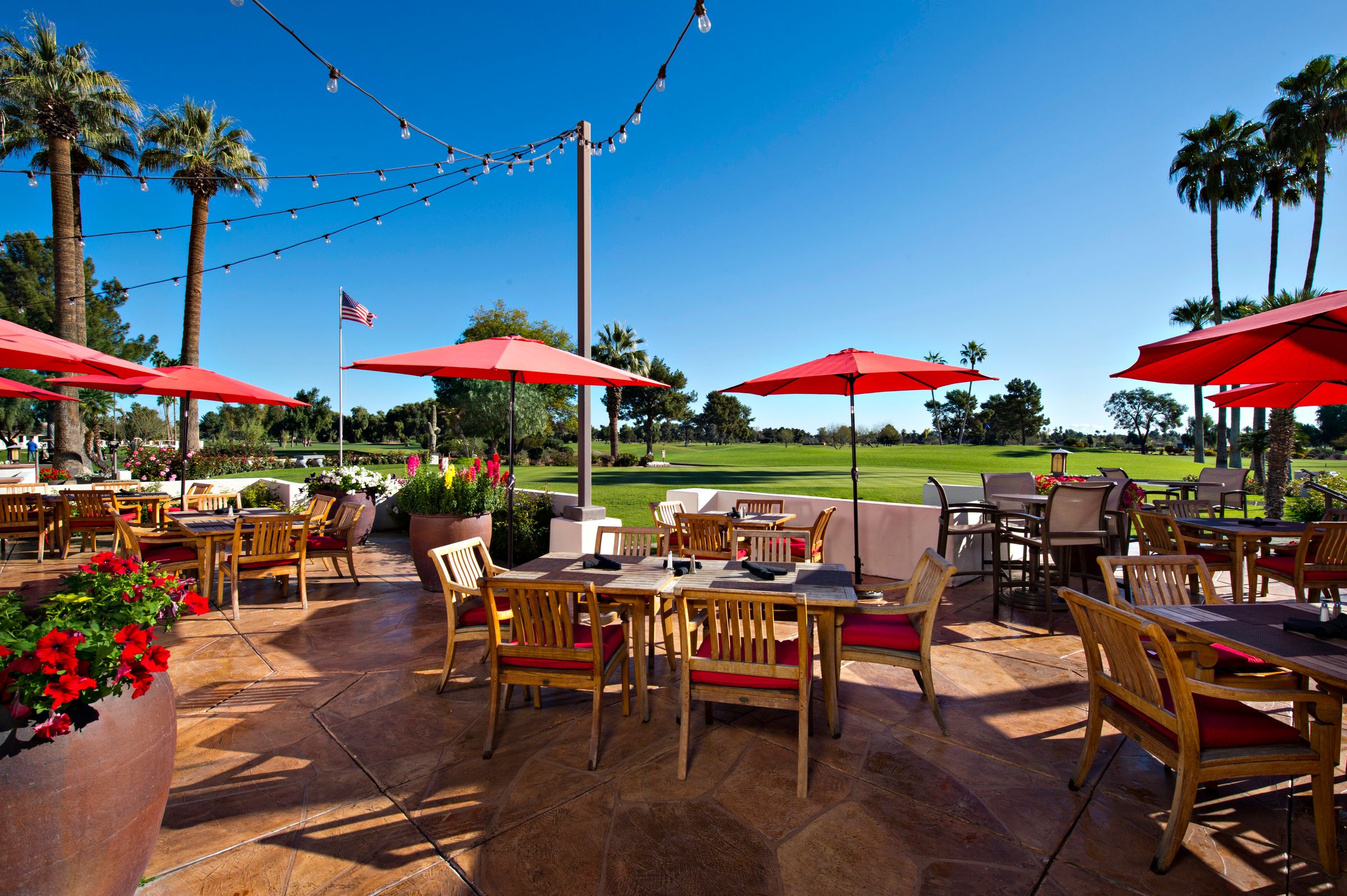 a patio with tables and umbrellas with ESPN Wide World of Sports Complex in the background