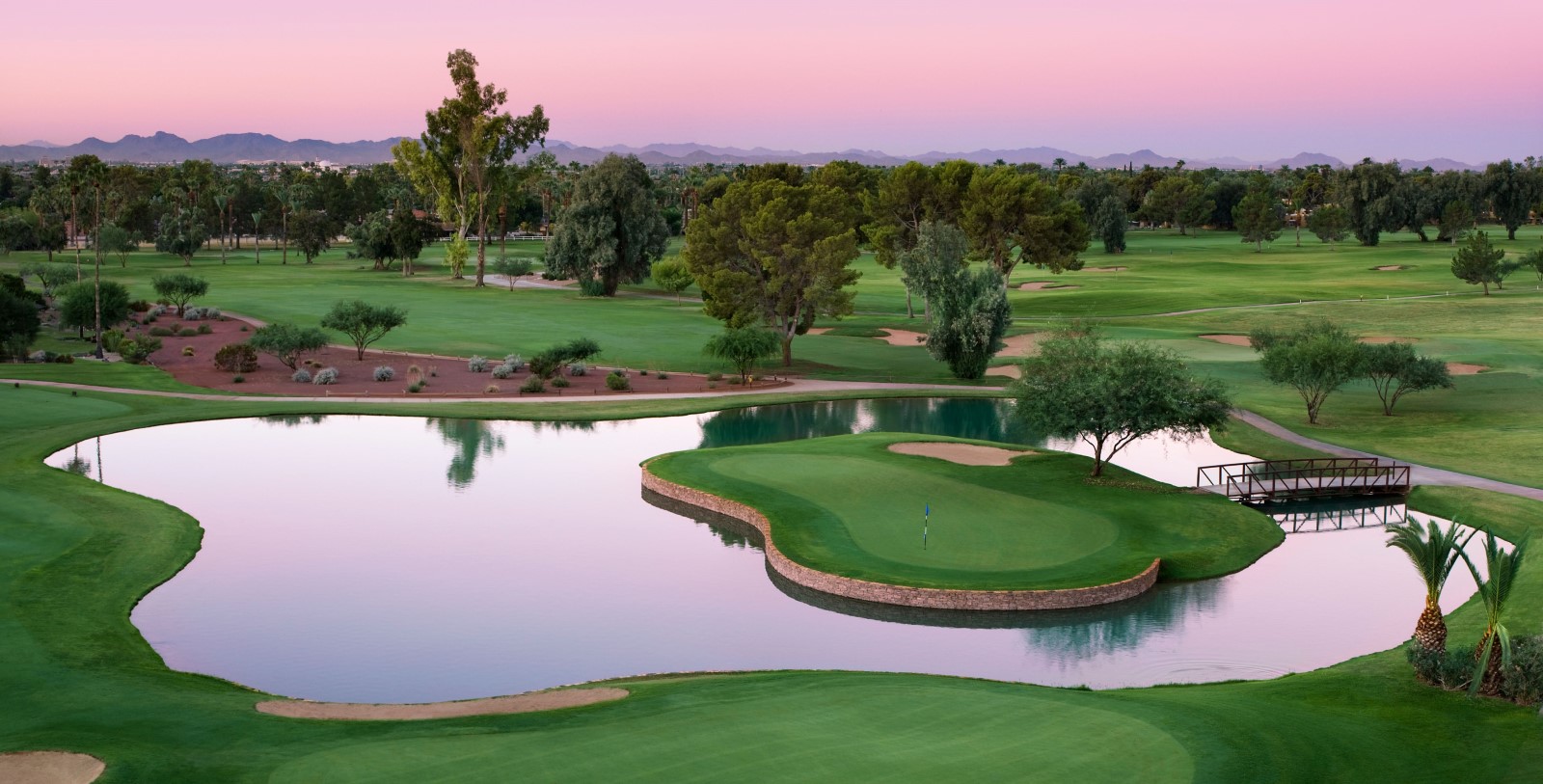 a golf course with a lake and trees