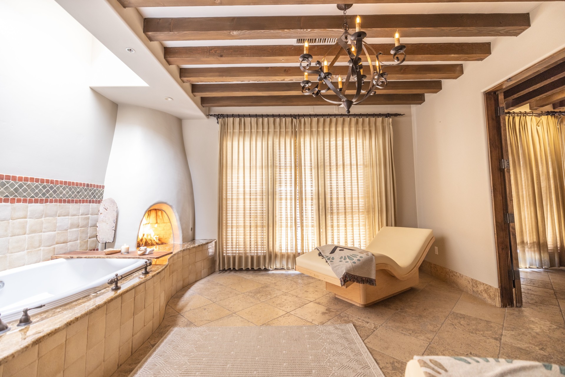 a room with a bathtub and a chandelier