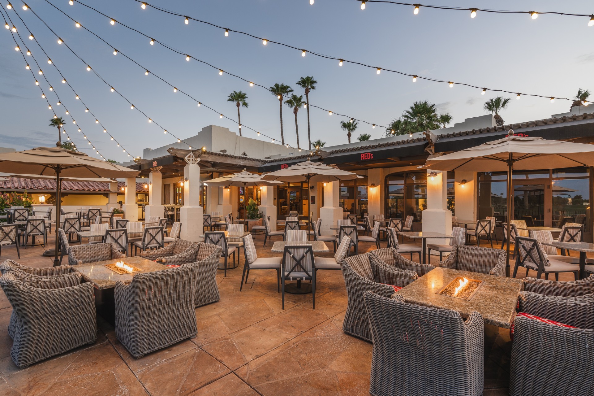 a patio with tables and chairs and lights