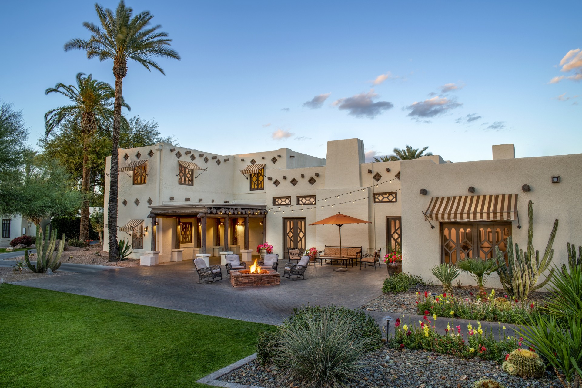 a house with a fire pit and palm trees