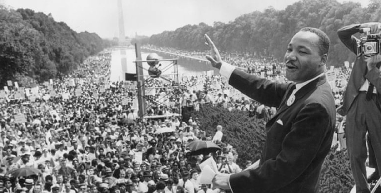 a man in a suit speaking to a crowd of people