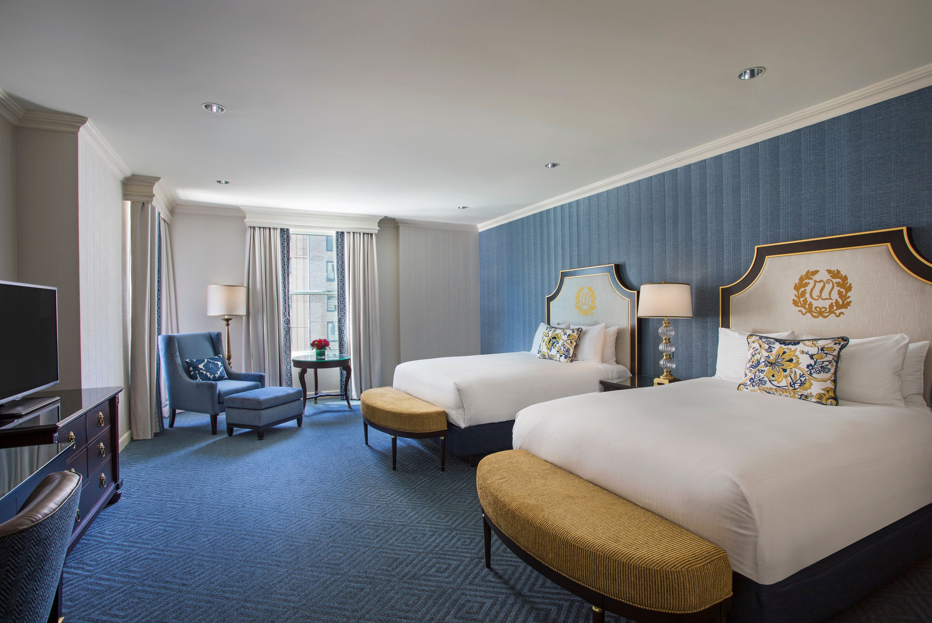 a room with two beds and a chair
