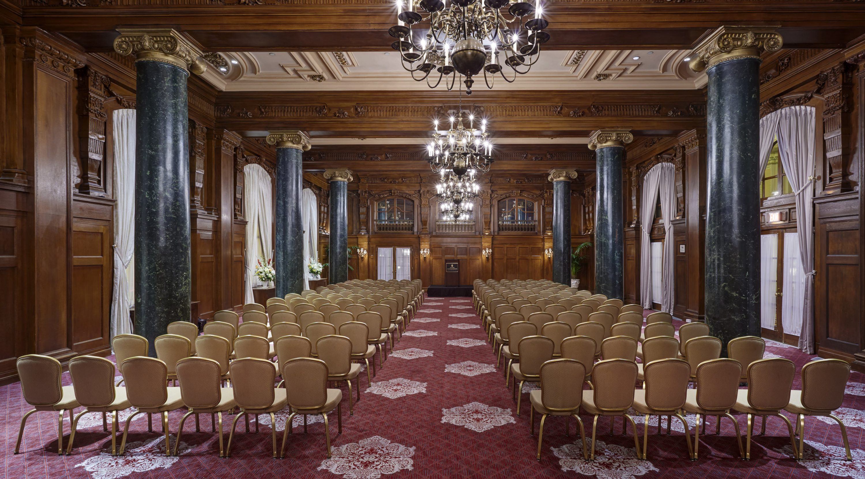 a room with chairs and chandeliers