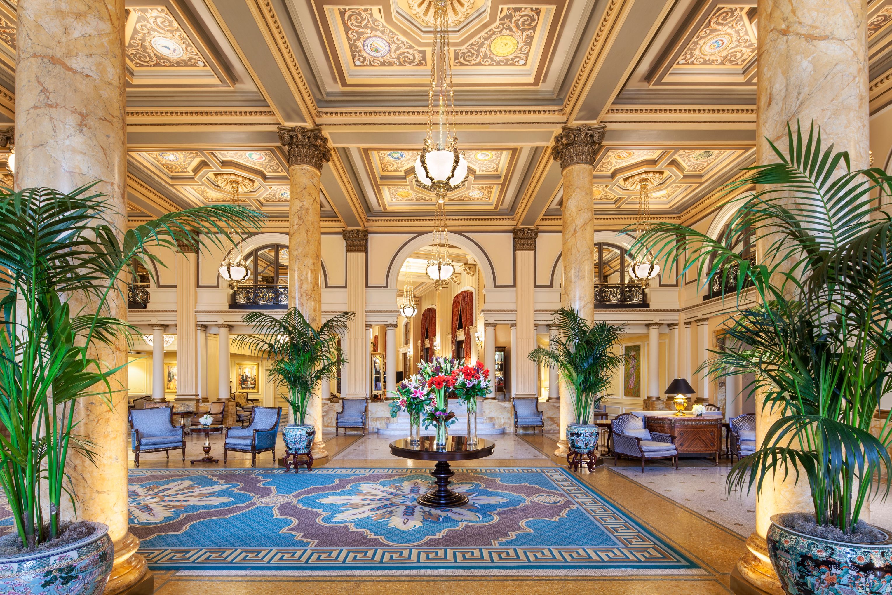 a large lobby with a large chandelier and chairs
