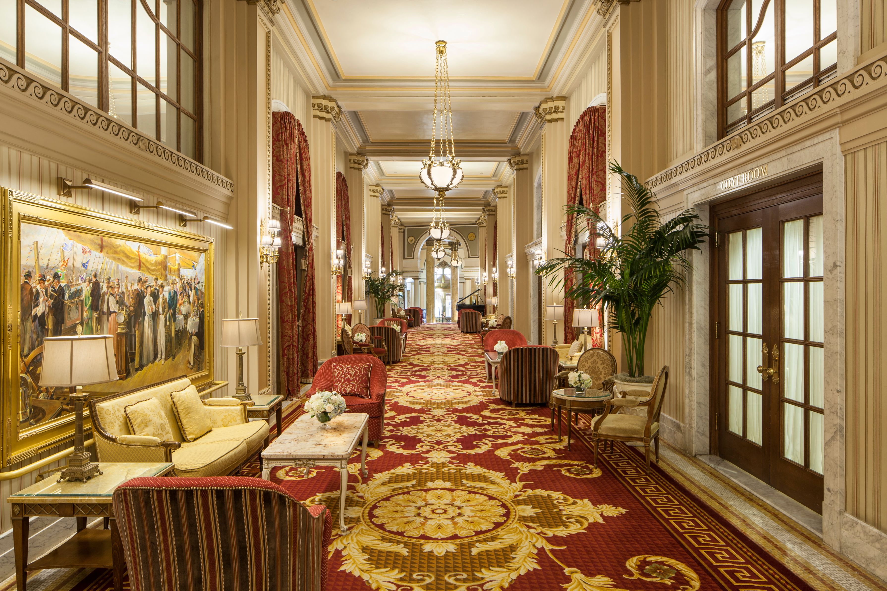 a long hallway with red carpet and chairs