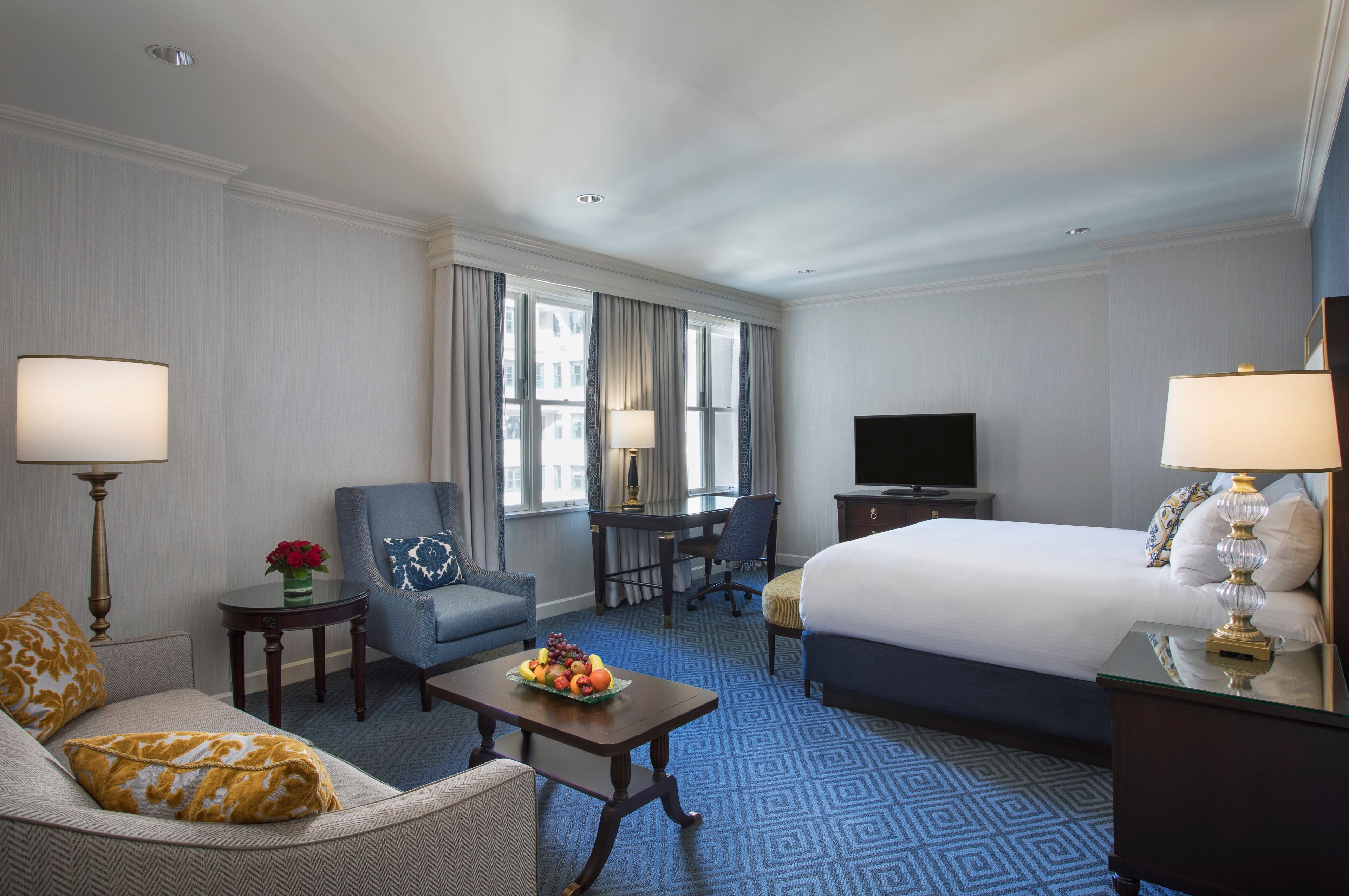a room with a bed and chairs