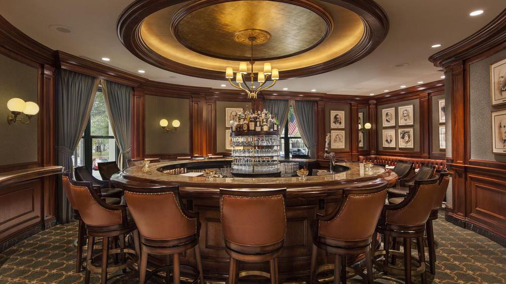 a bar with a round counter and chairs