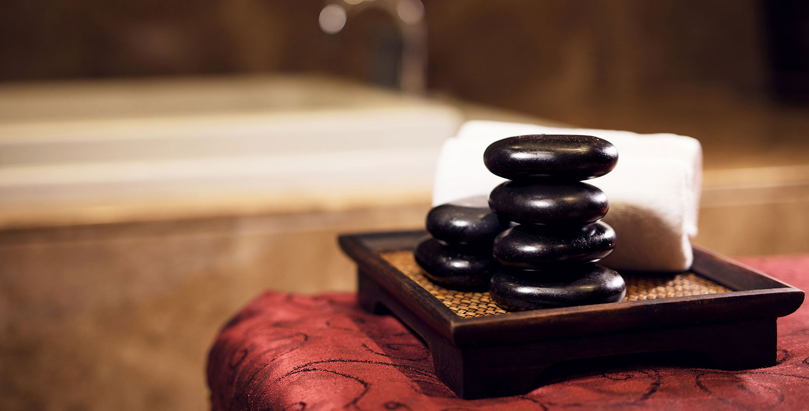 a stack of black stones on a wooden surface
