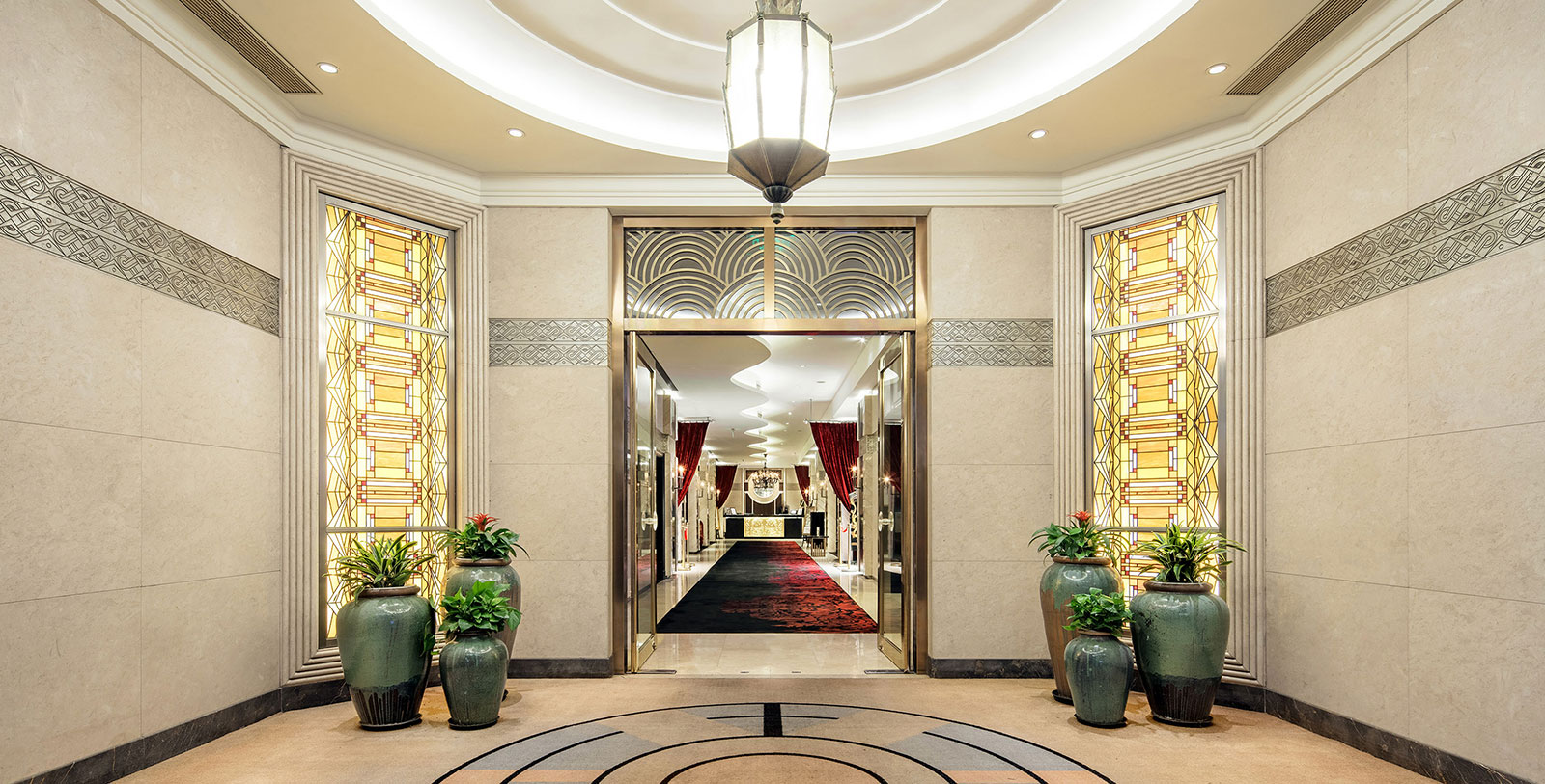 a hallway with a large glass door and plants