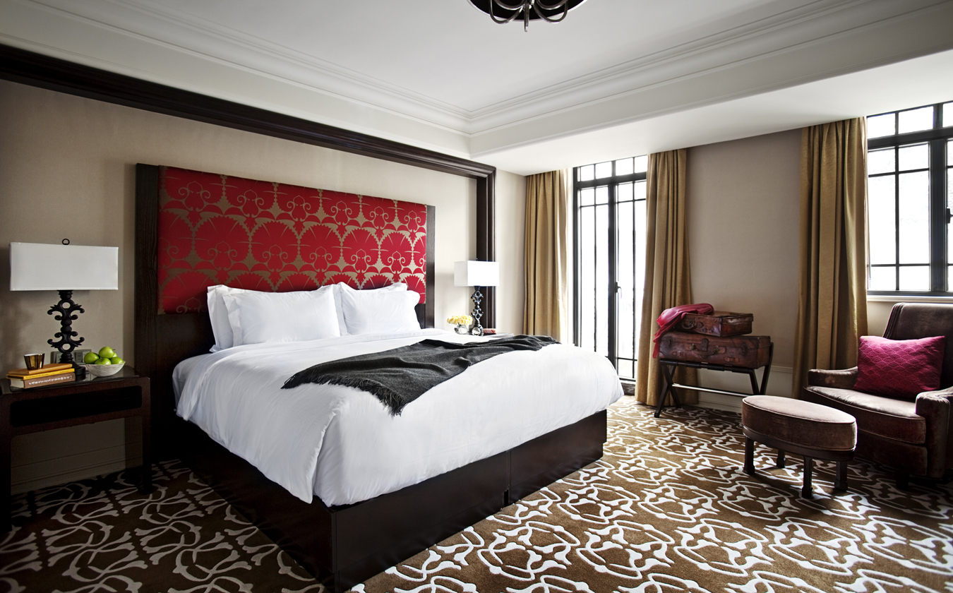 a bed with a red headboard in a hotel room
