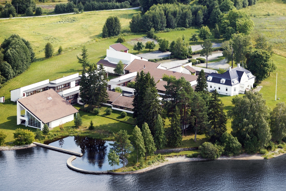 a large building surrounded by trees and water