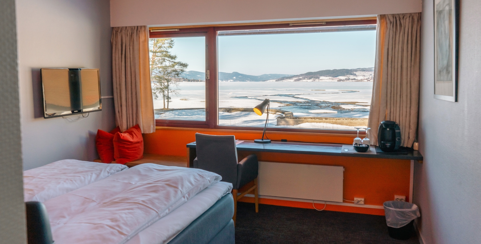 a room with a window and a bed and chair