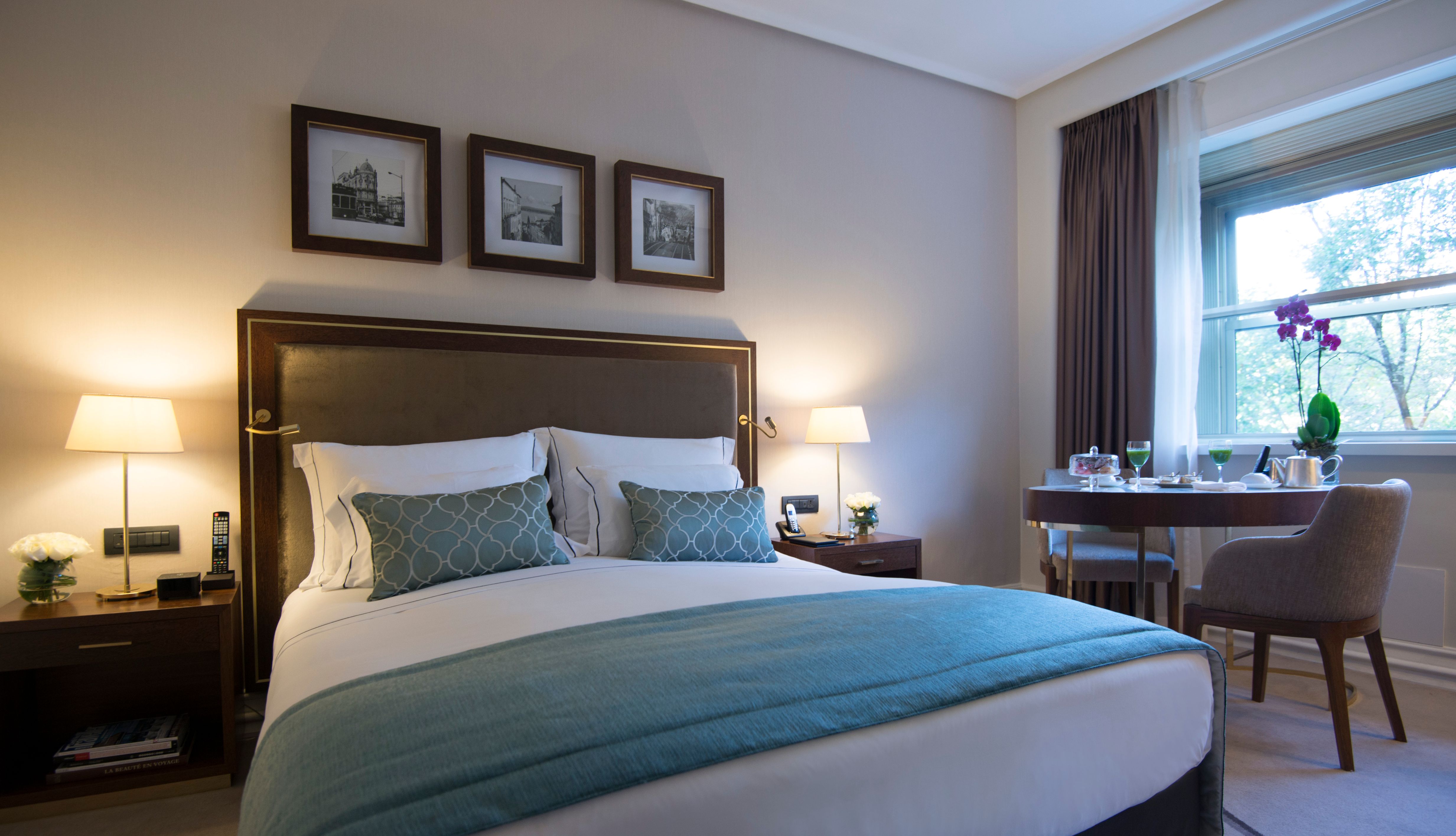 a bed with a blue blanket and a table with lamps