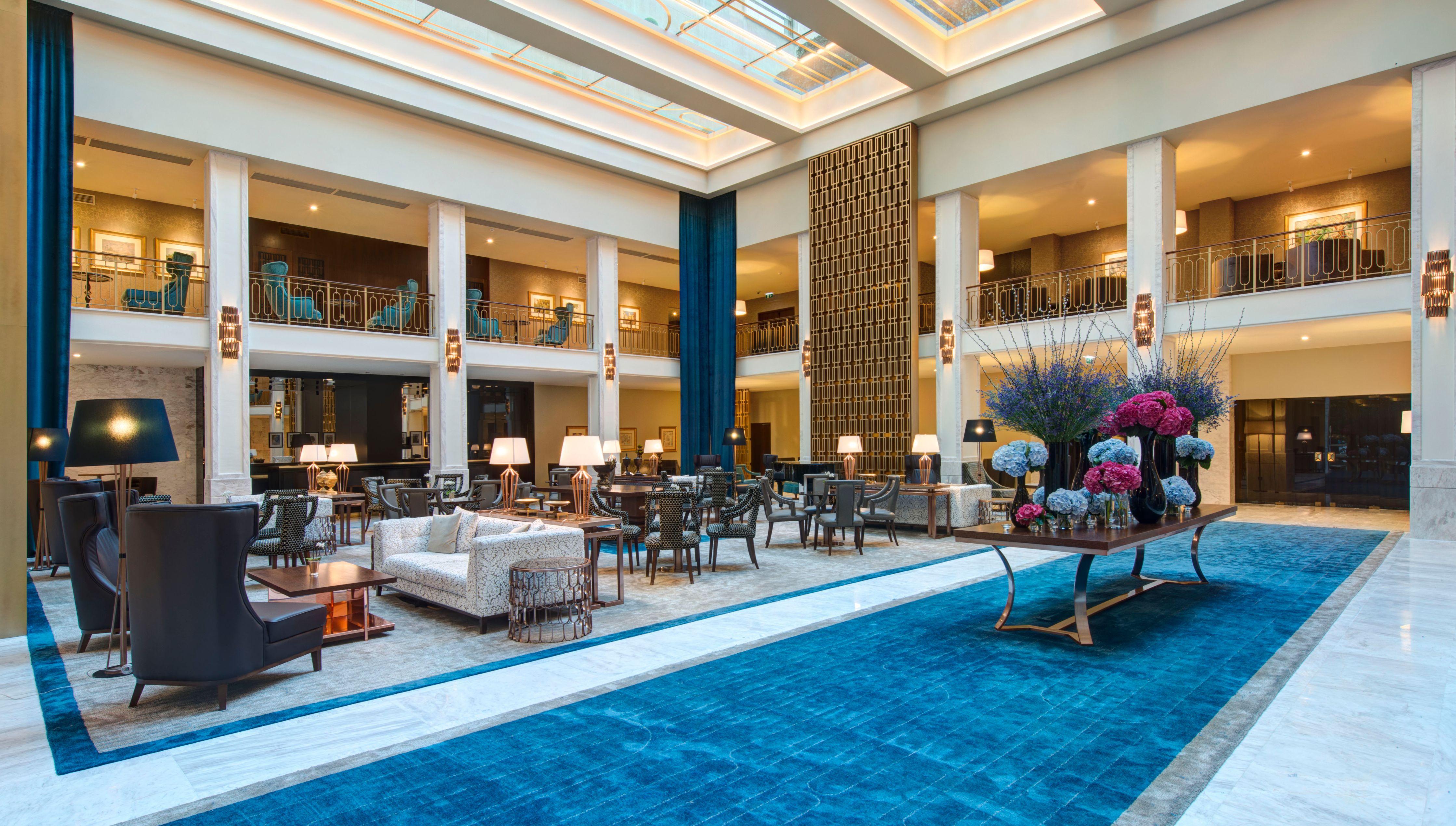 a large room with a blue carpet and tables and chairs