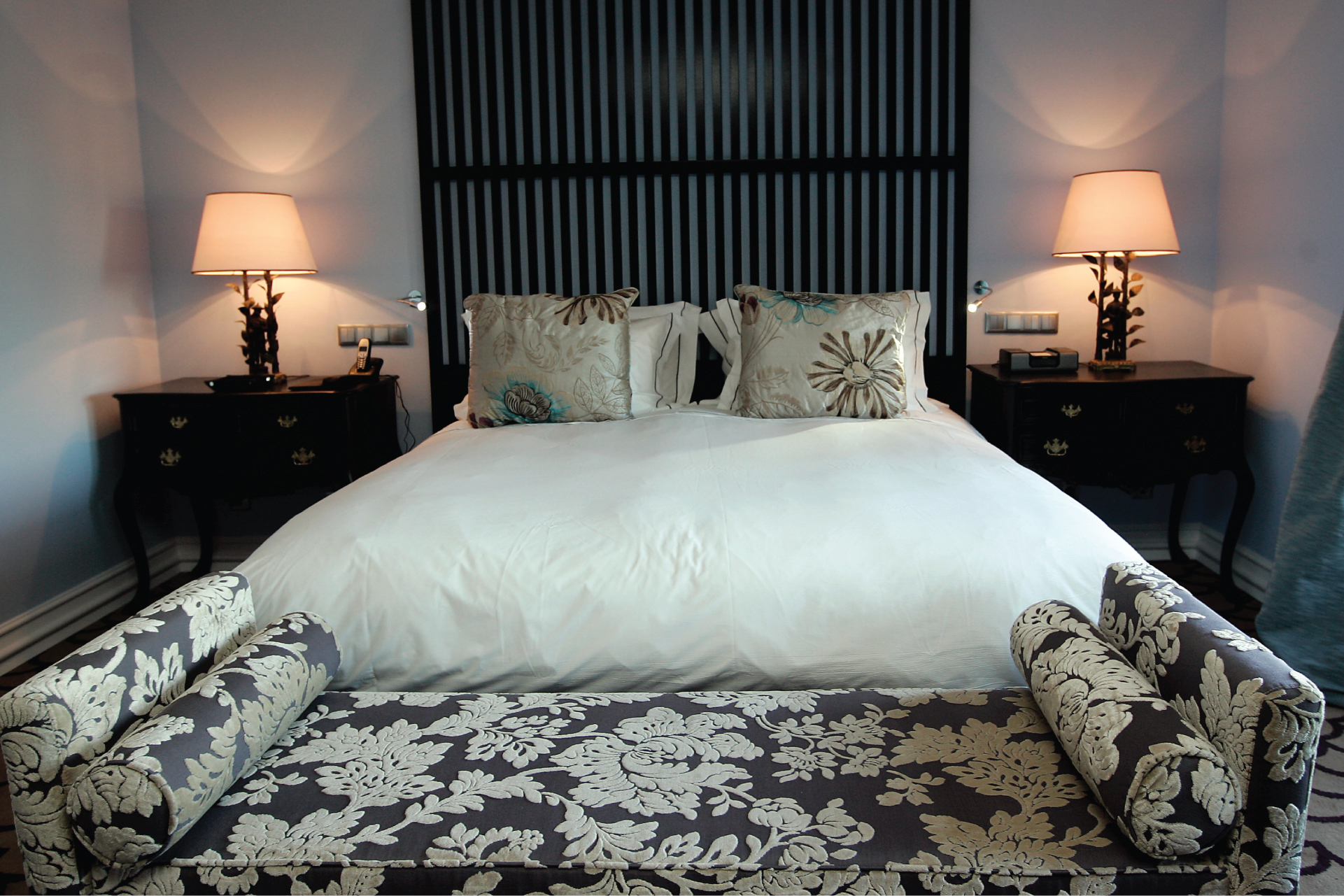 a bed with two chairs and a lamp
