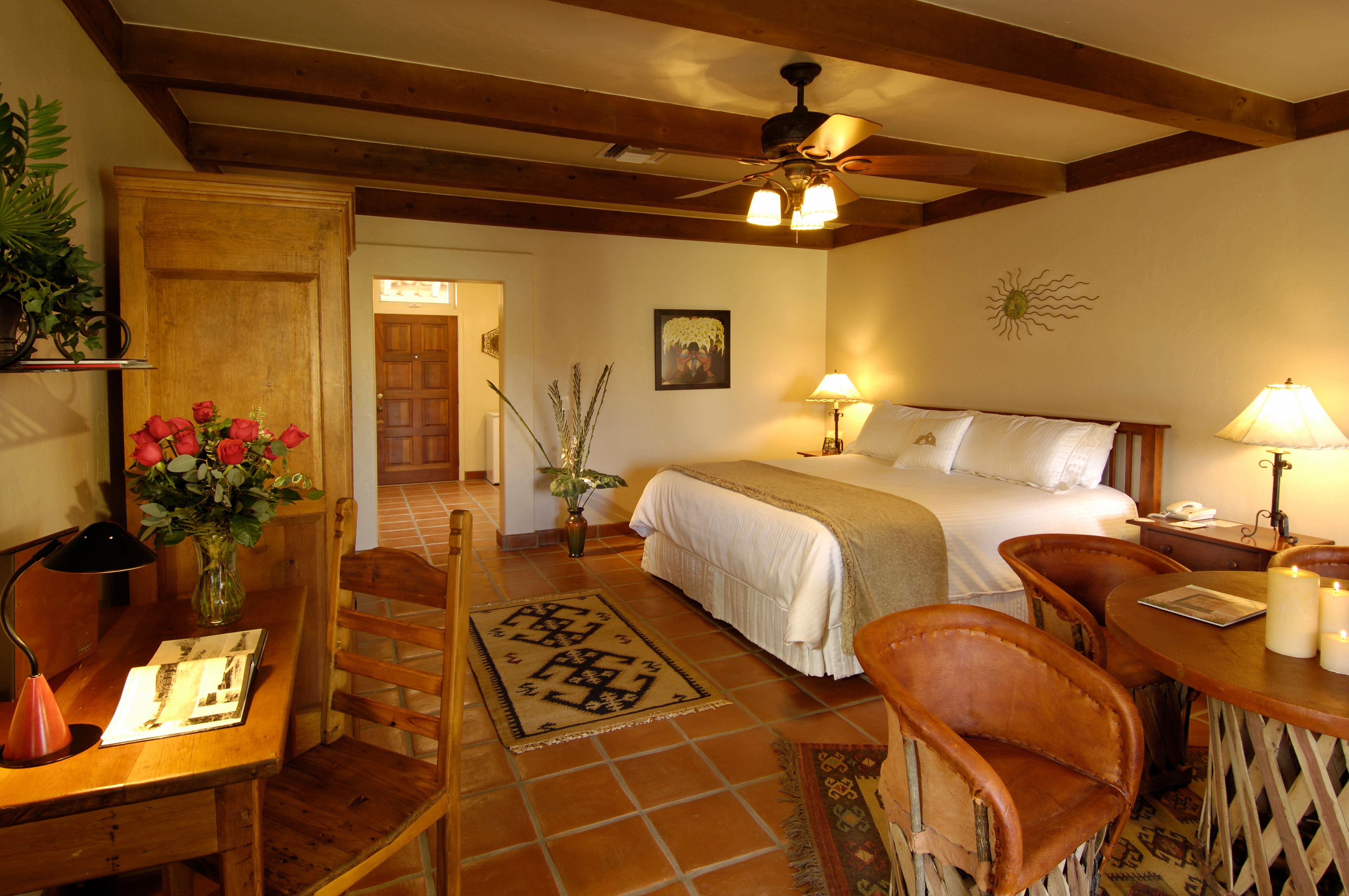 a room with a bed and chairs