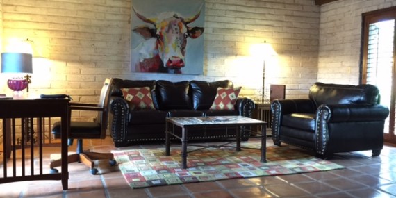 a living room with a cow painting