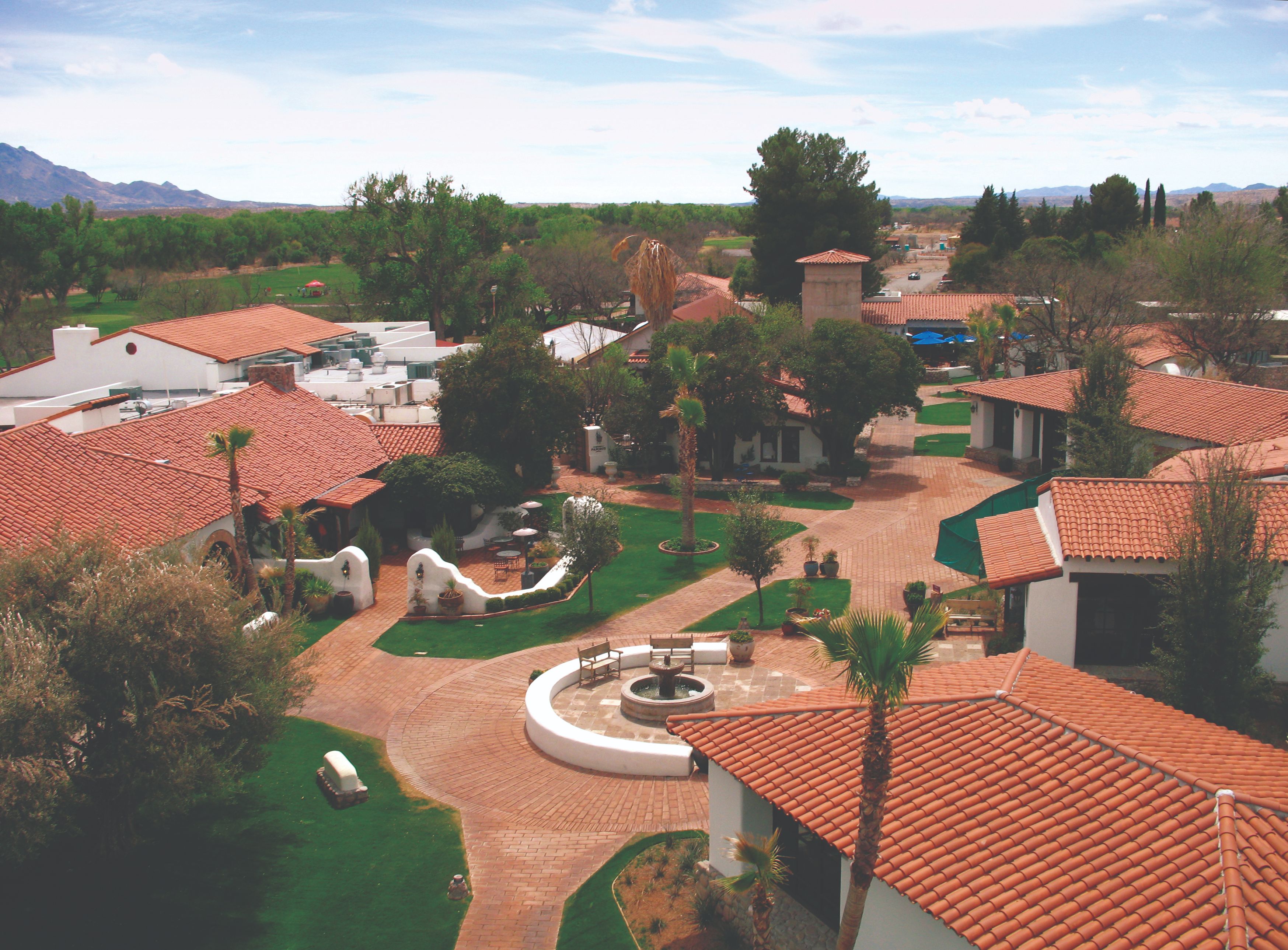 a aerial view of a courtyard with a fountain and trees