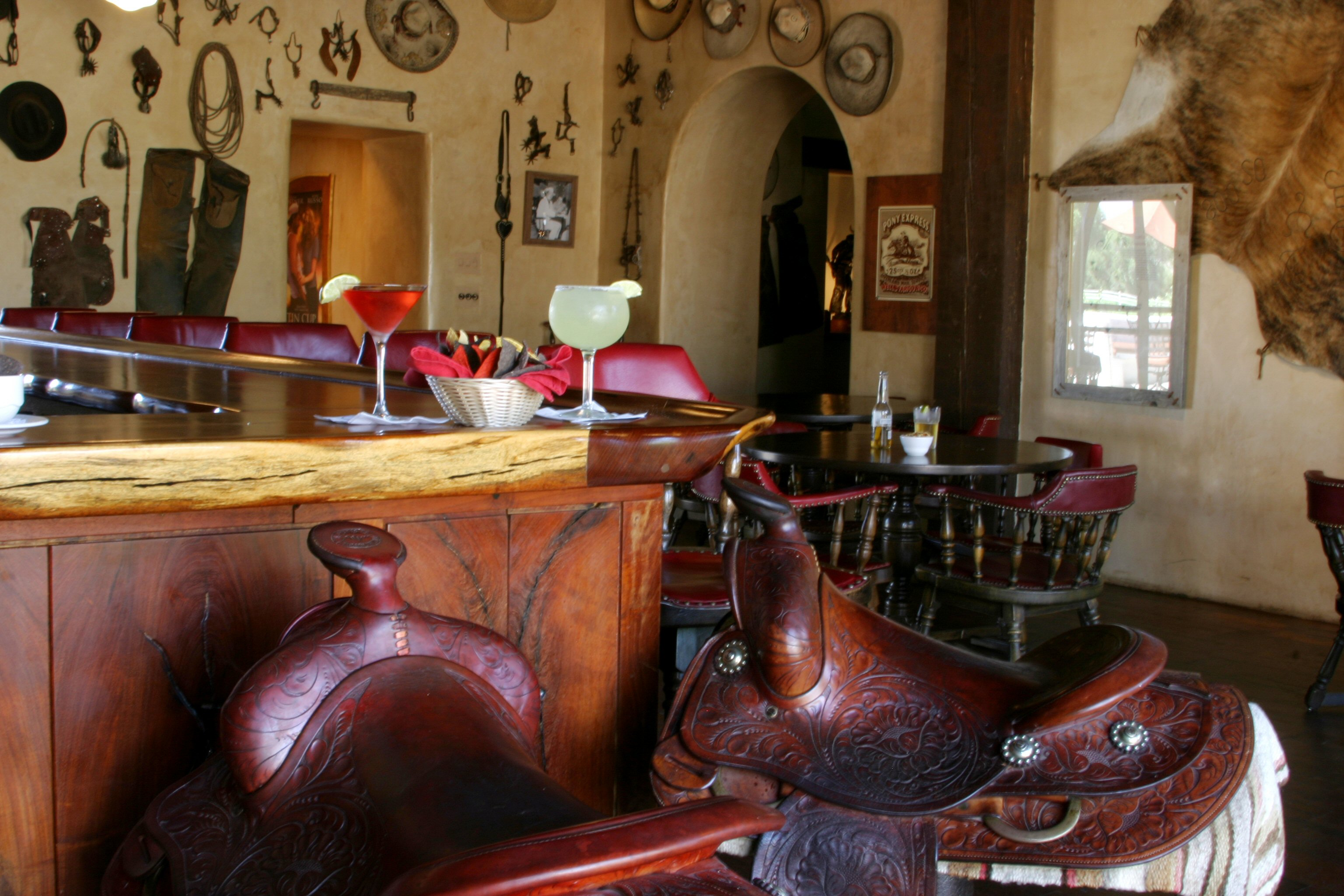 a bar with a drink and saddles