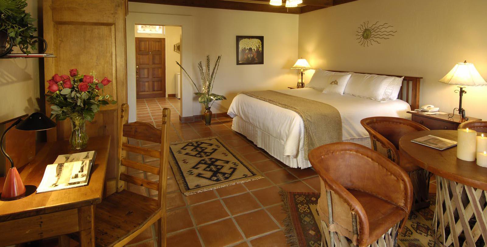 a bedroom with a bed and chairs