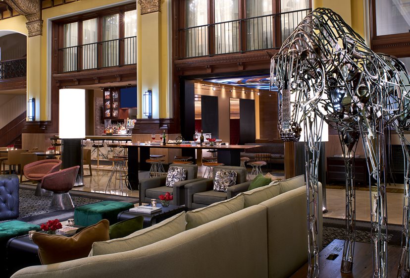a room with a large metal statue and a bar