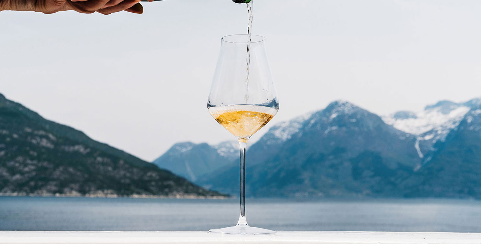 a person pouring a glass of wine