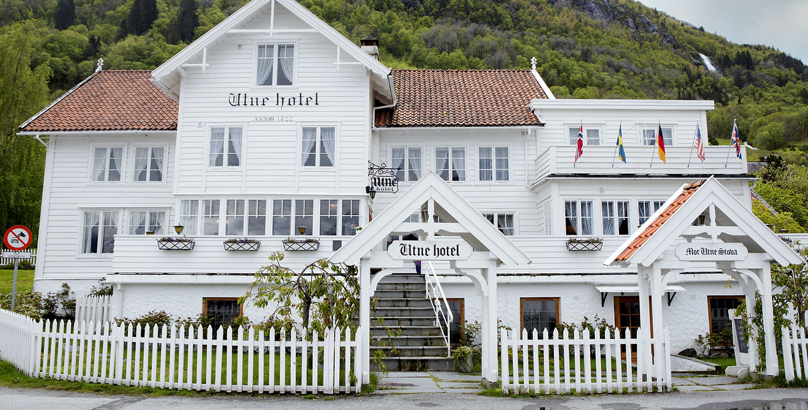 a white building with a white fence and a white gate