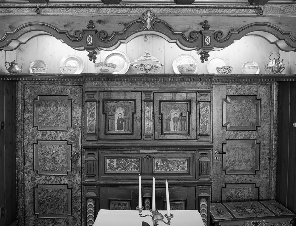 a black and white photo of a cabinet with a table and chairs