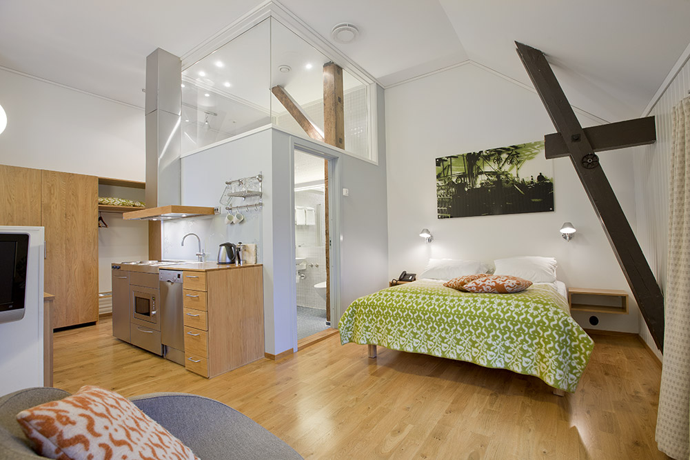 a bedroom with a bed and a kitchen