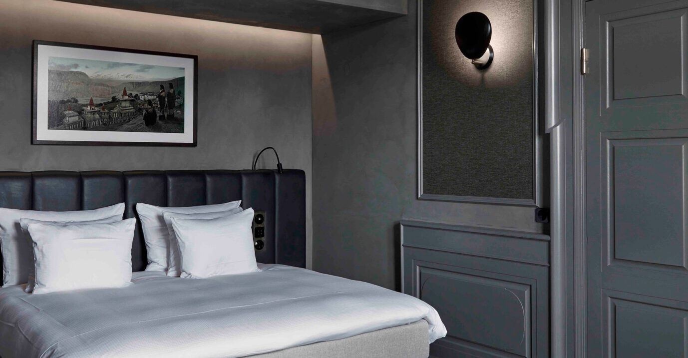 a bed with white pillows and a black headboard