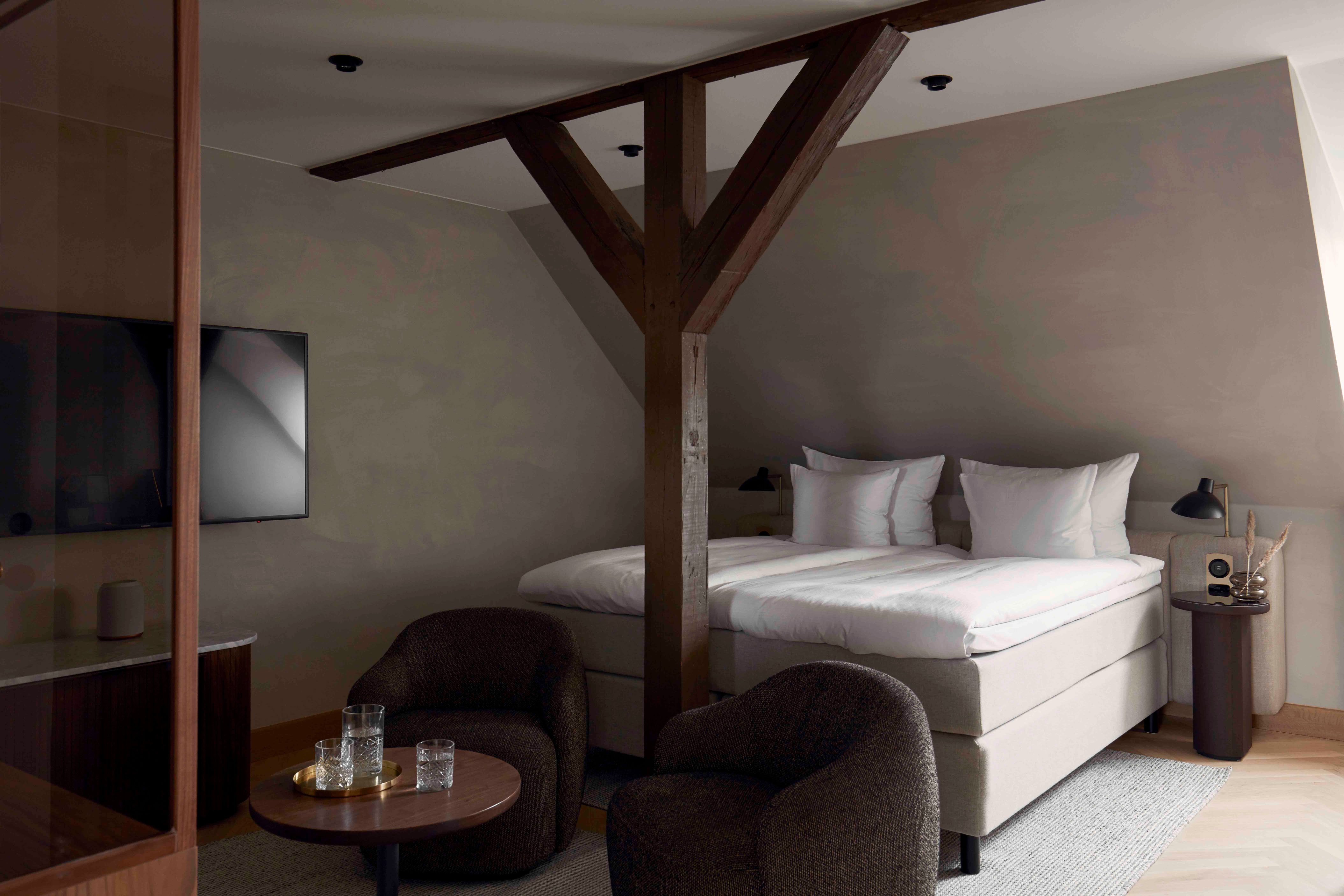 a room with a bed and chairs