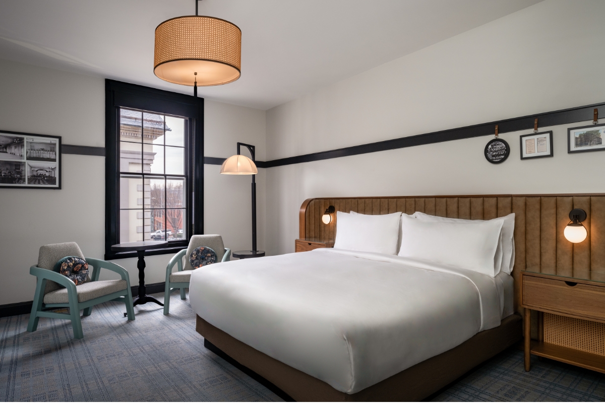 a room with a bed and chairs